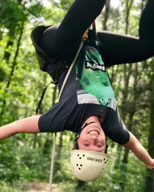 Ashley Kirvin hanging upside down from zipline