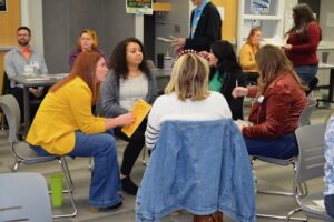 group of individuals playing the roles of family members discussing during poverty simulation